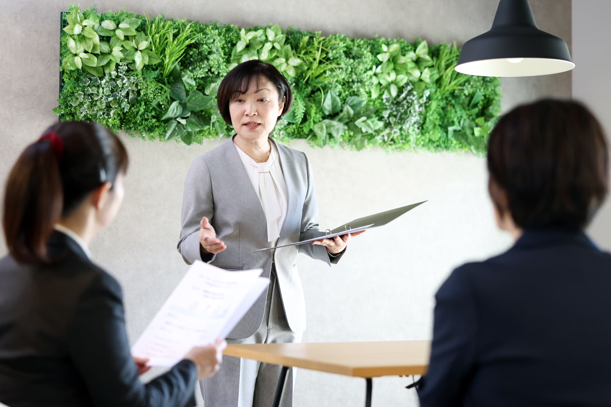 打ち合わせに笑顔で参加する２人の社員